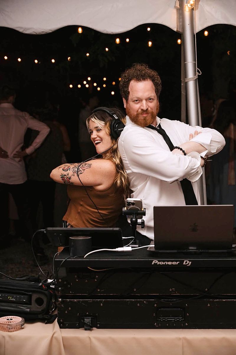 Dave Menzo and Heather back to back at his DJ booth at her wedding