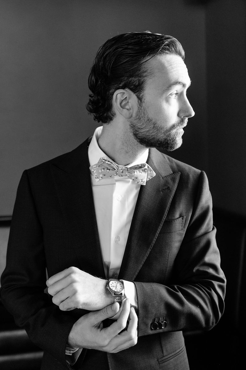 Dennis fastening his cufflinks, in black and white