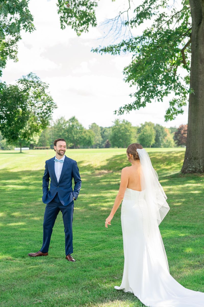 Dennis smiling as Katie walks toward him