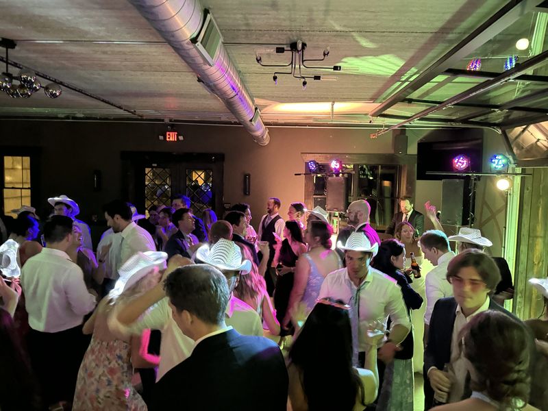A full dance floor in white cowboy hats at Katie and Dennis's reception at Revel Run