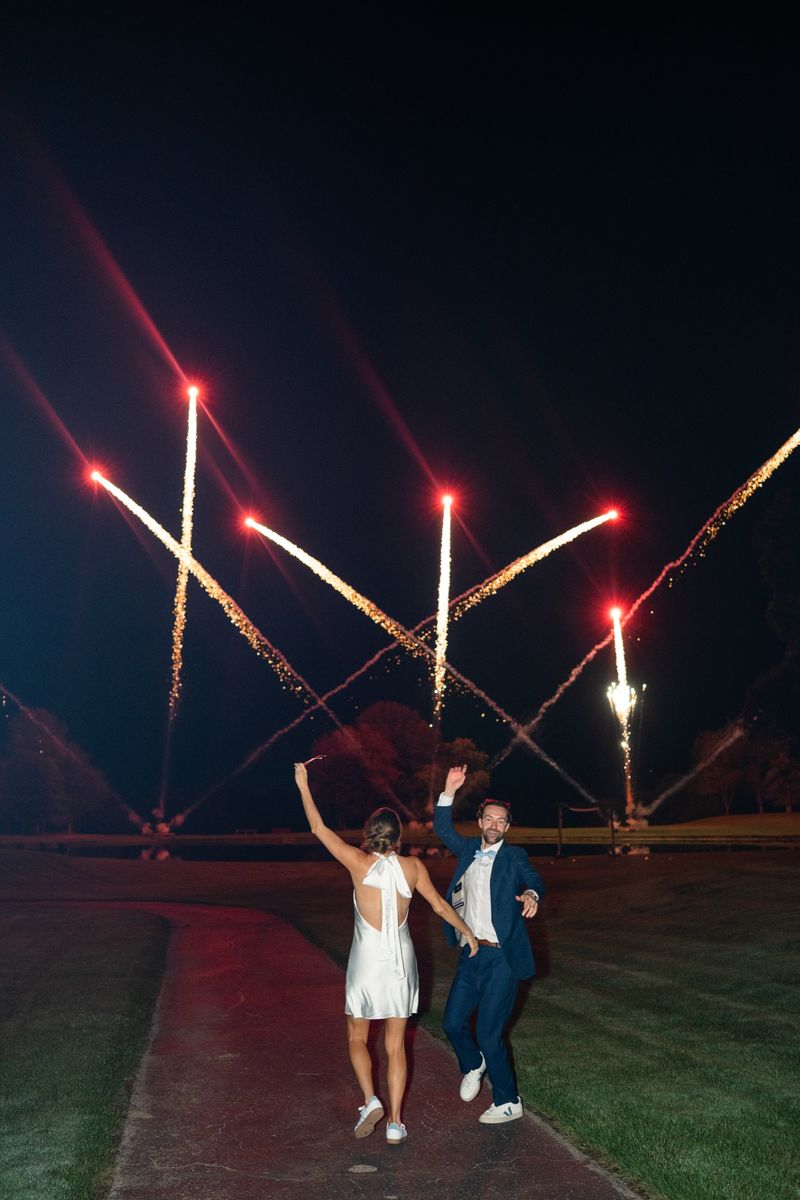 Katie and Dennis dancing on the path as fireworks rise over Revel Run