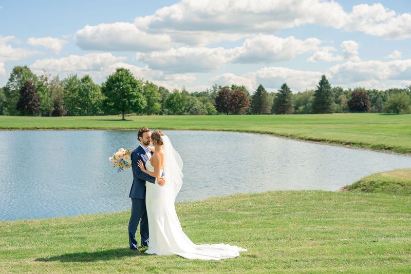 Katie and Dennis kissing beside the pond at Revel Run