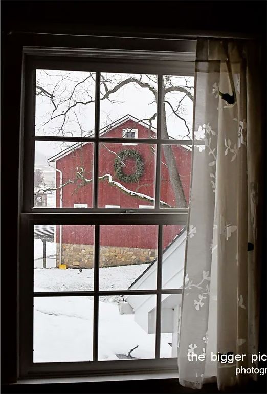 The red barn seen through a farmhouse window