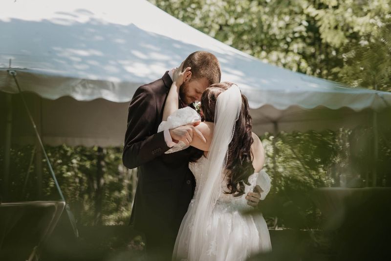 Heather and Tyler kissing under the tent