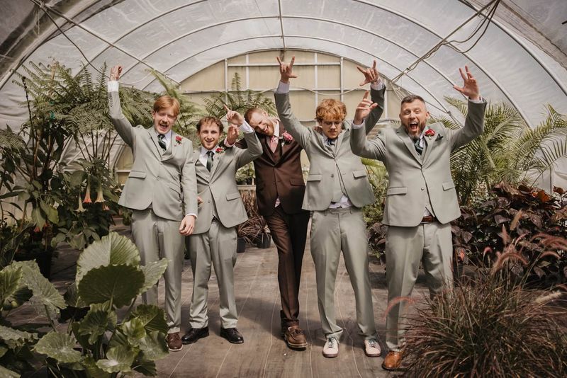The groomsmen cheering in the greenhouse