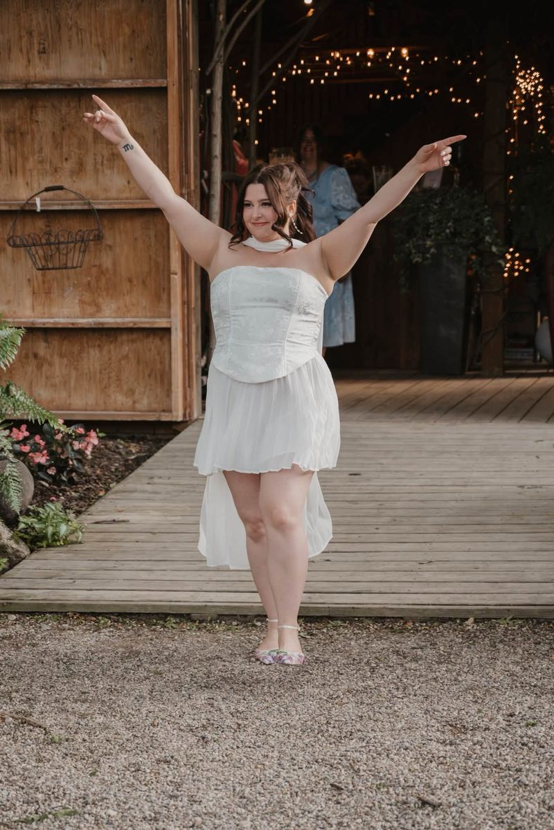 Heather in her party dress, arms in the air