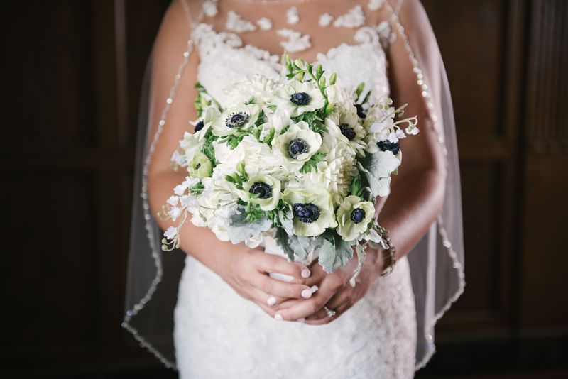 Patricia's bouquet of white anemones against her lace gown