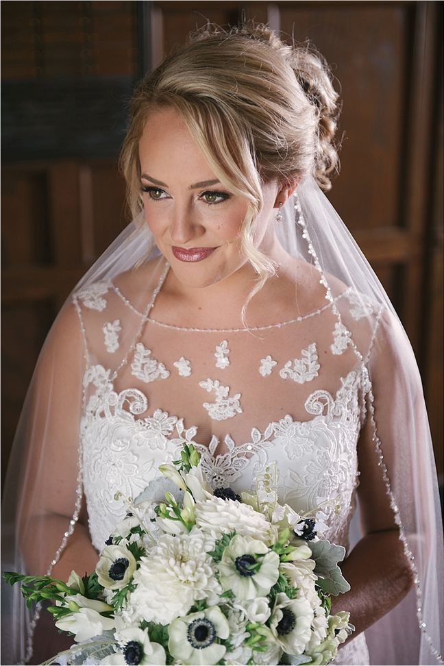 Patricia in her veil holding her bouquet of white anemones