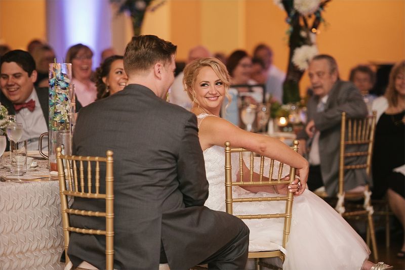 Patricia and Bryan laughing at their table during the toasts